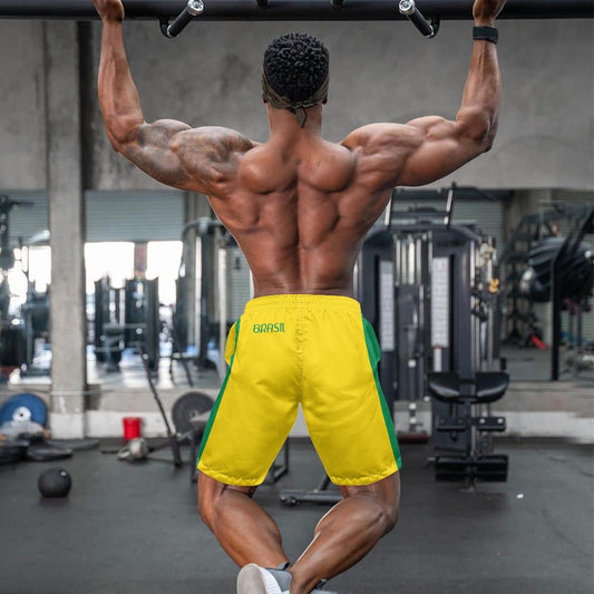 Back view of yellow and green Brazil flag inspired beach shorts with Brasil text, worn by muscular man working out at gym