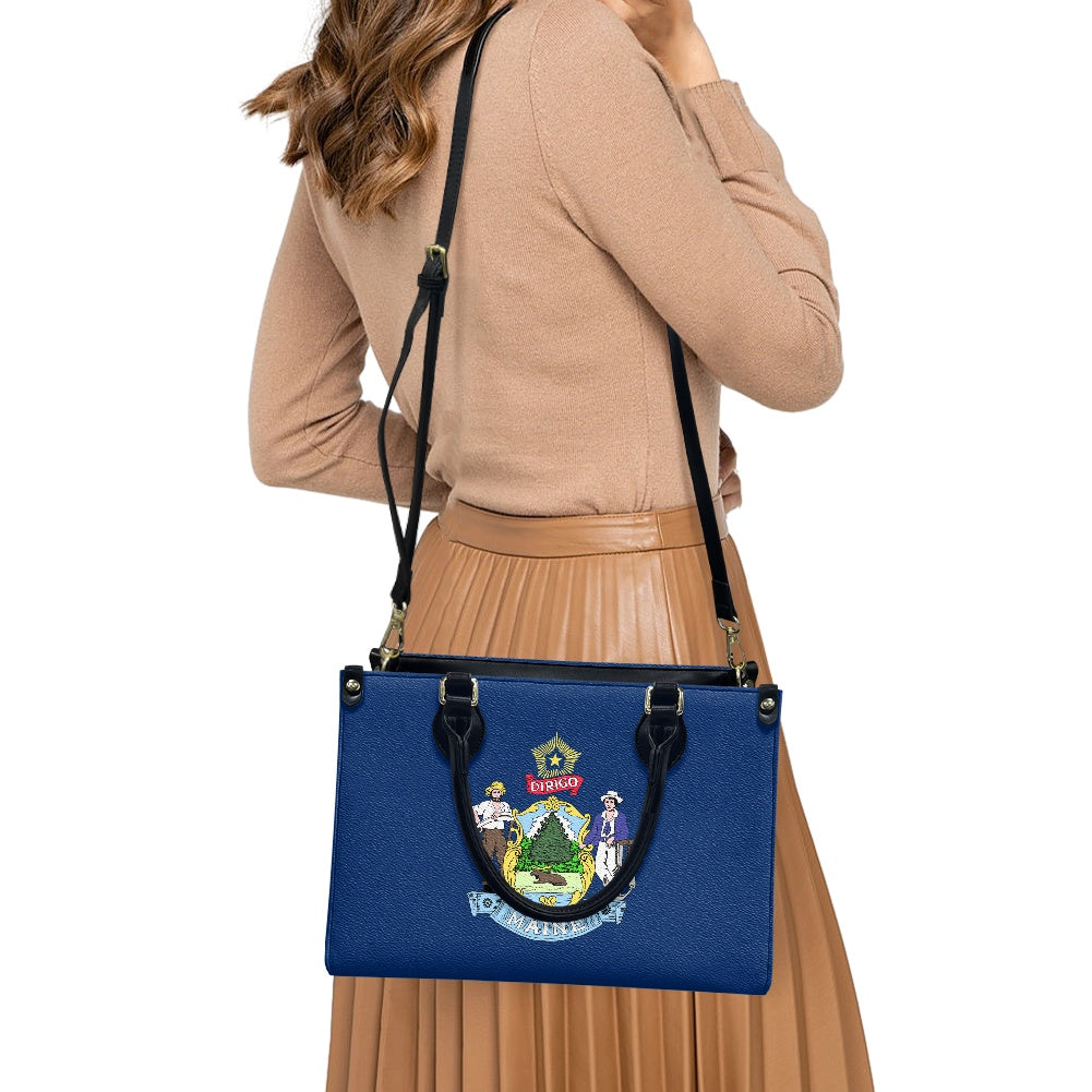 Woman holding blue [Brand] handbag with emblem, wearing beige.