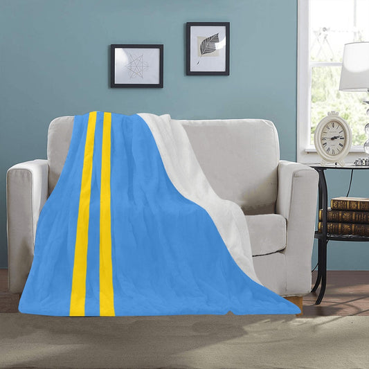 Blue and yellow [Luv My Flag] blanket draped over sofa.
