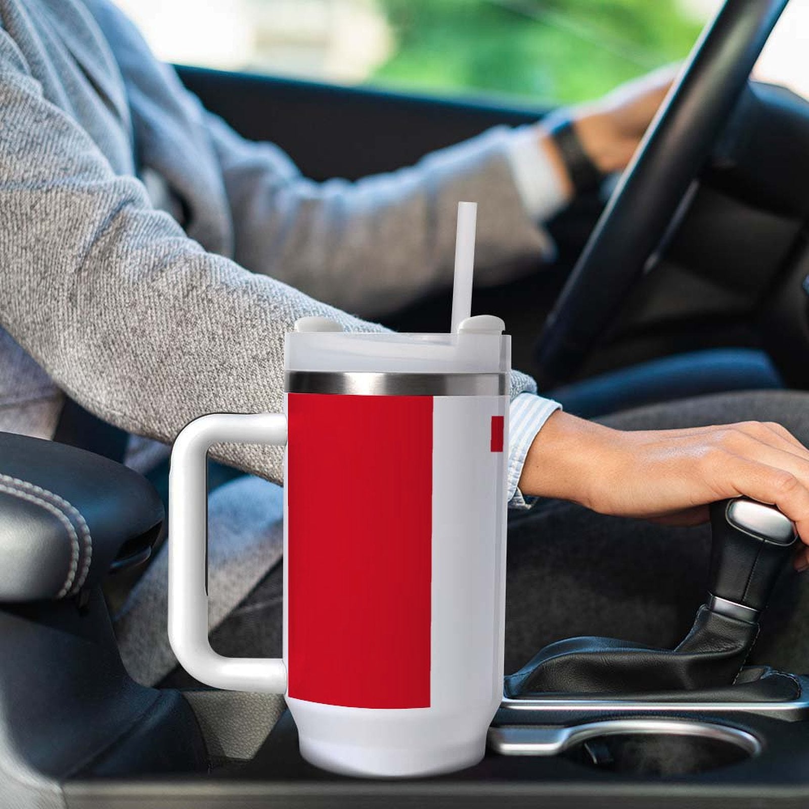 Driver holding a [Brand] travel mug with red design.