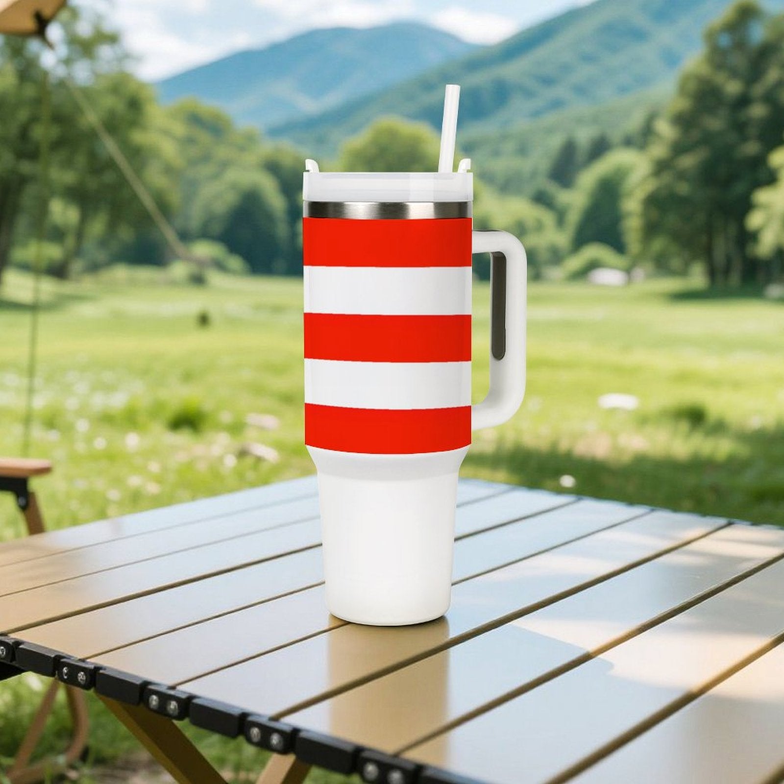 [Brand] striped tumbler with straw on outdoor table, nature background.
