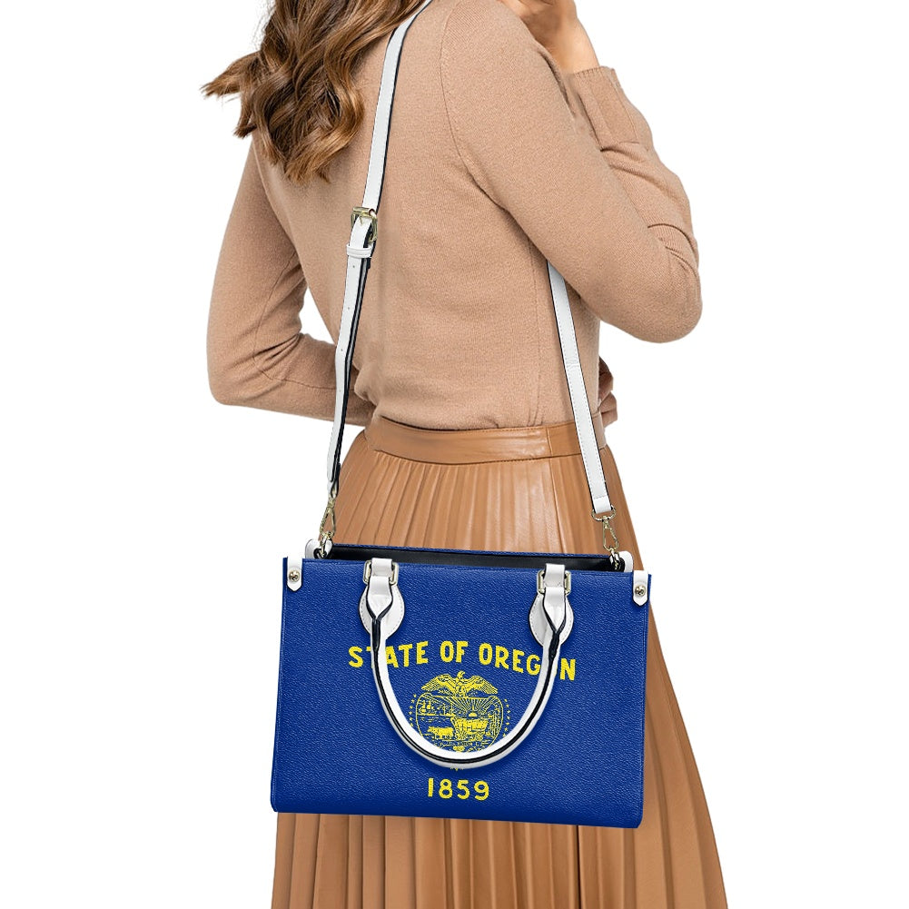 Woman holding blue [Brand] handbag with Oregon state emblem.