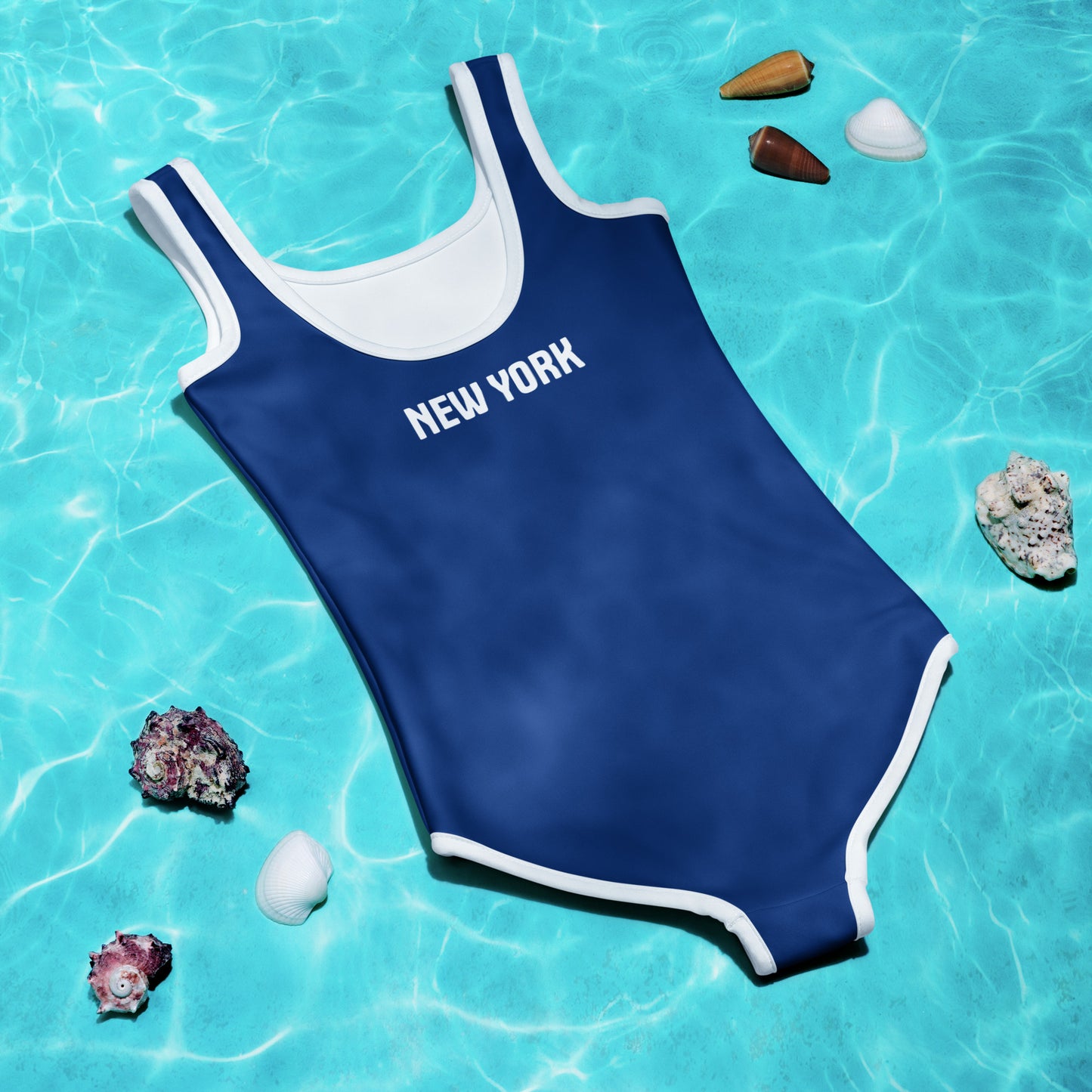 [Brand] blue swimsuit floating in pool with seashells.