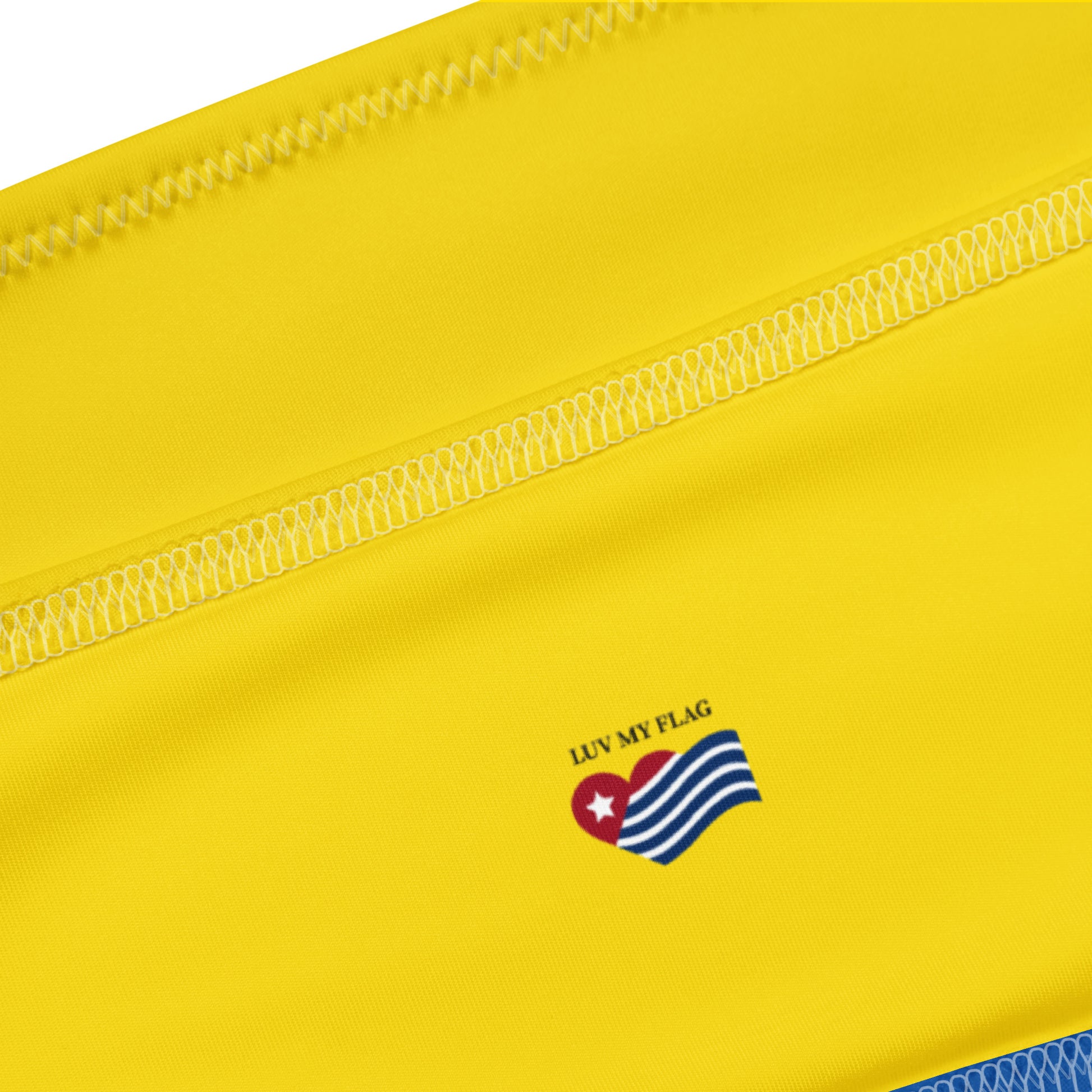 Yellow [Brand] cloth detail with flag heart design, stitching.
