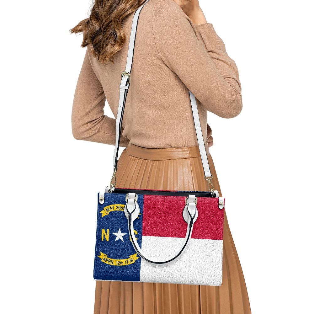 Woman carrying [Brand] handbag with North Carolina flag design.