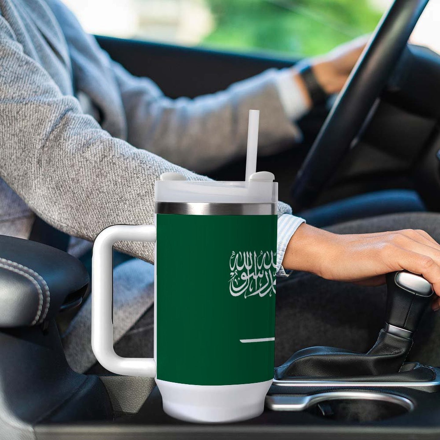 Person driving with [Brand] mug featuring Arabic script design.