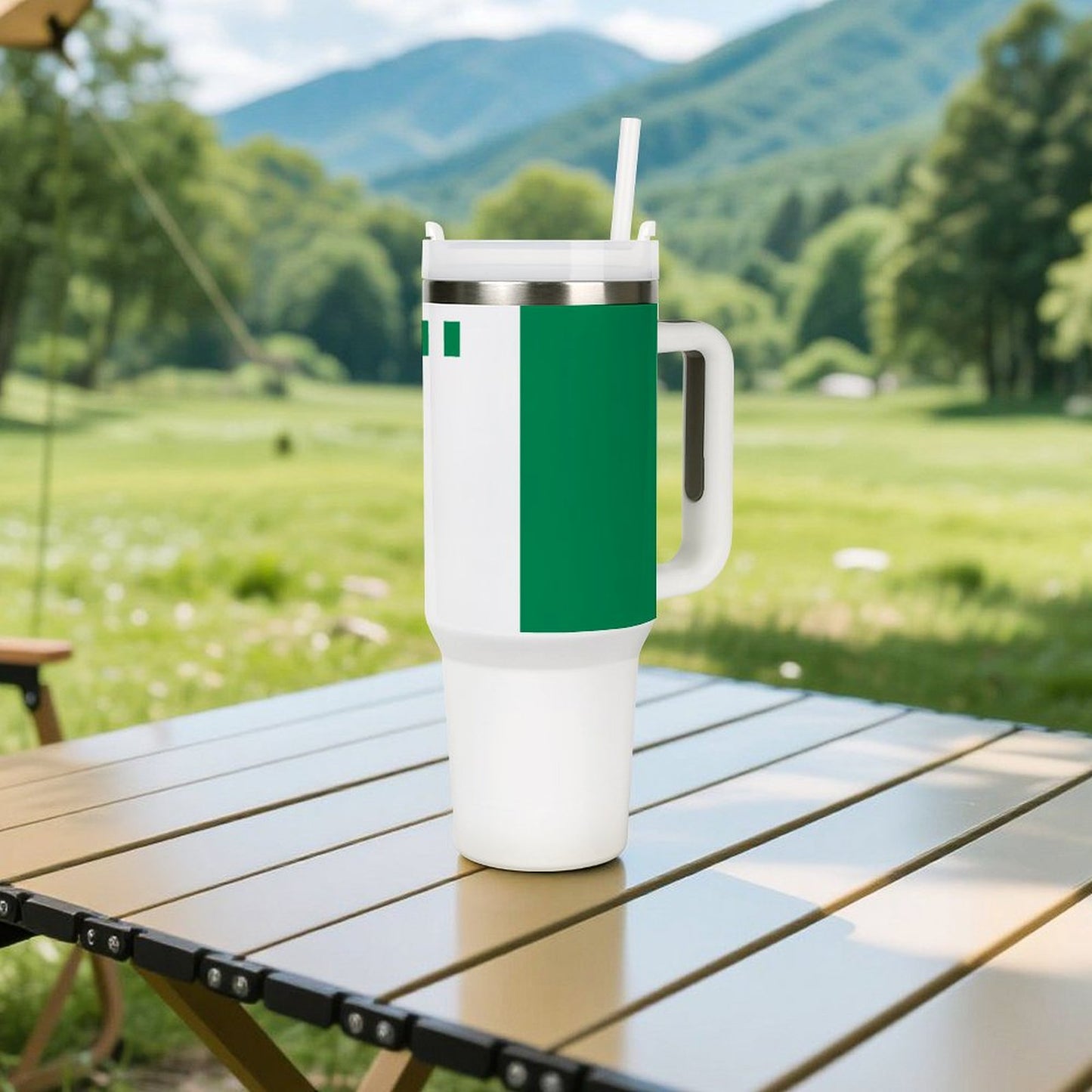[Brand] tumbler on table with scenic green mountain background.