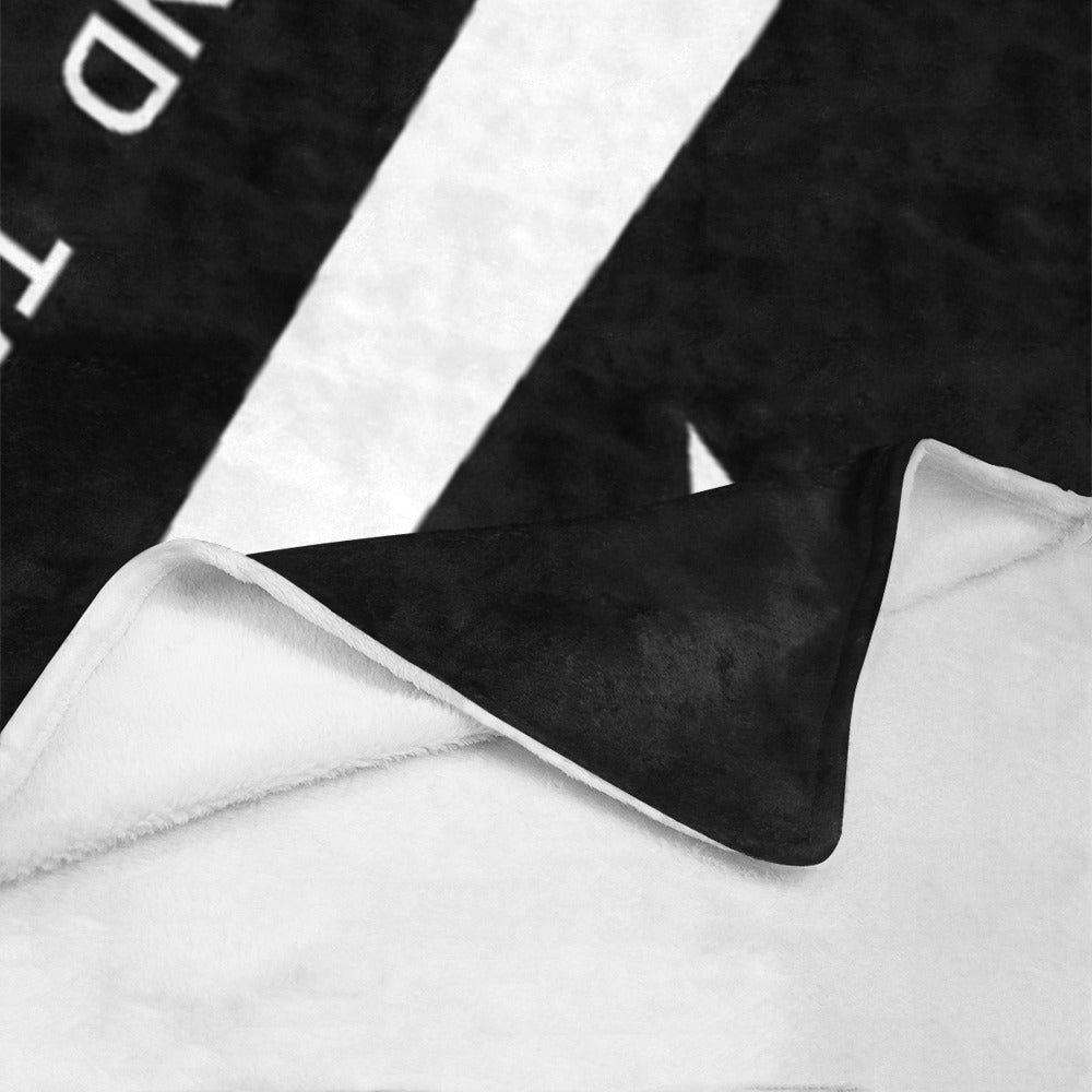 Black and white blanket by Luv My Flag, partially folded.