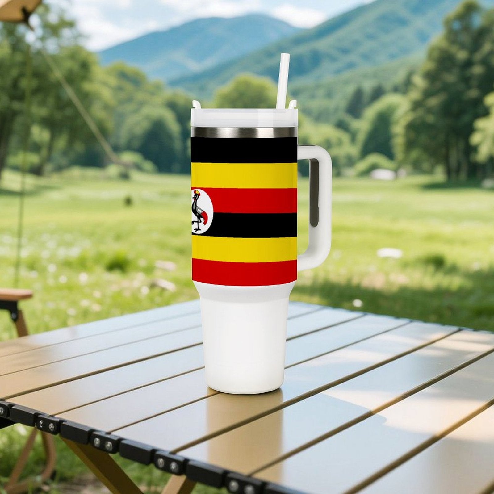 Travel mug on table featuring Uganda flag, outdoorsy scene, [Brand].