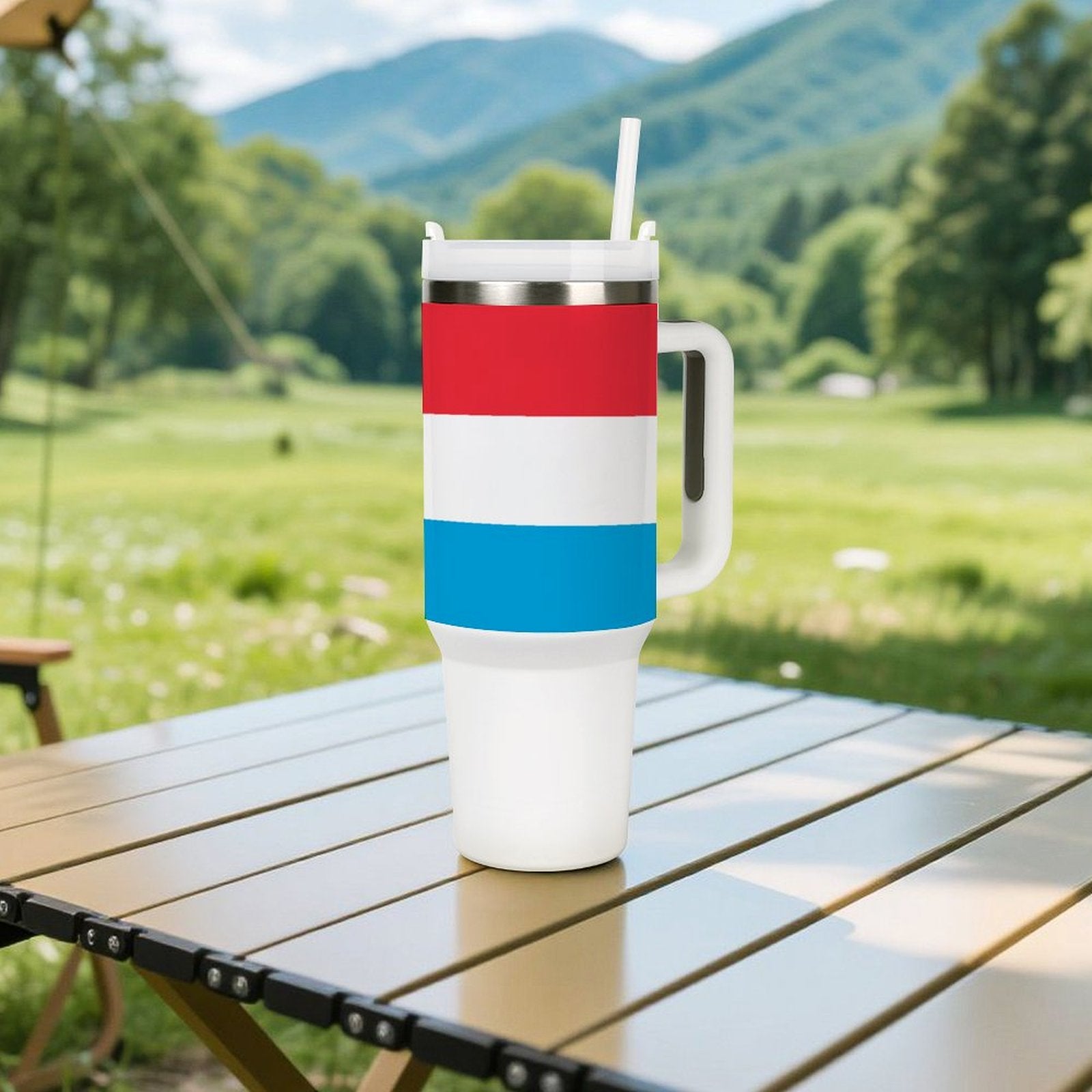 [Brand] tumbler with handle on a wooden picnic table.