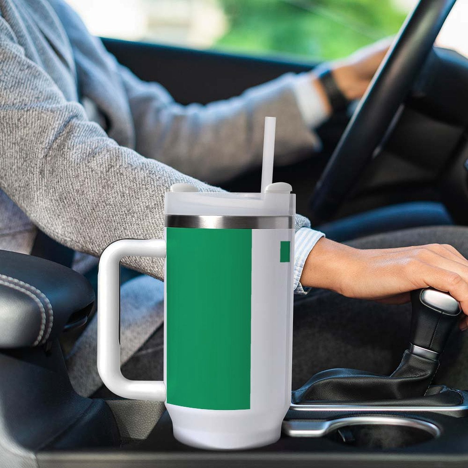 Person driving with large [Brand] mug in cup holder.