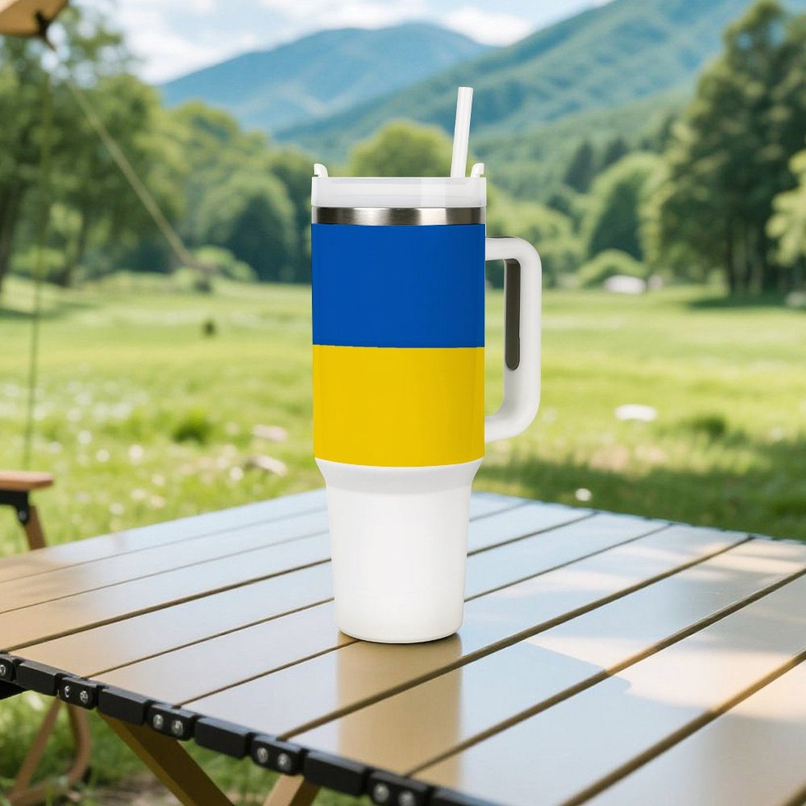 [Brand] cup with blue-yellow design on outdoor table.