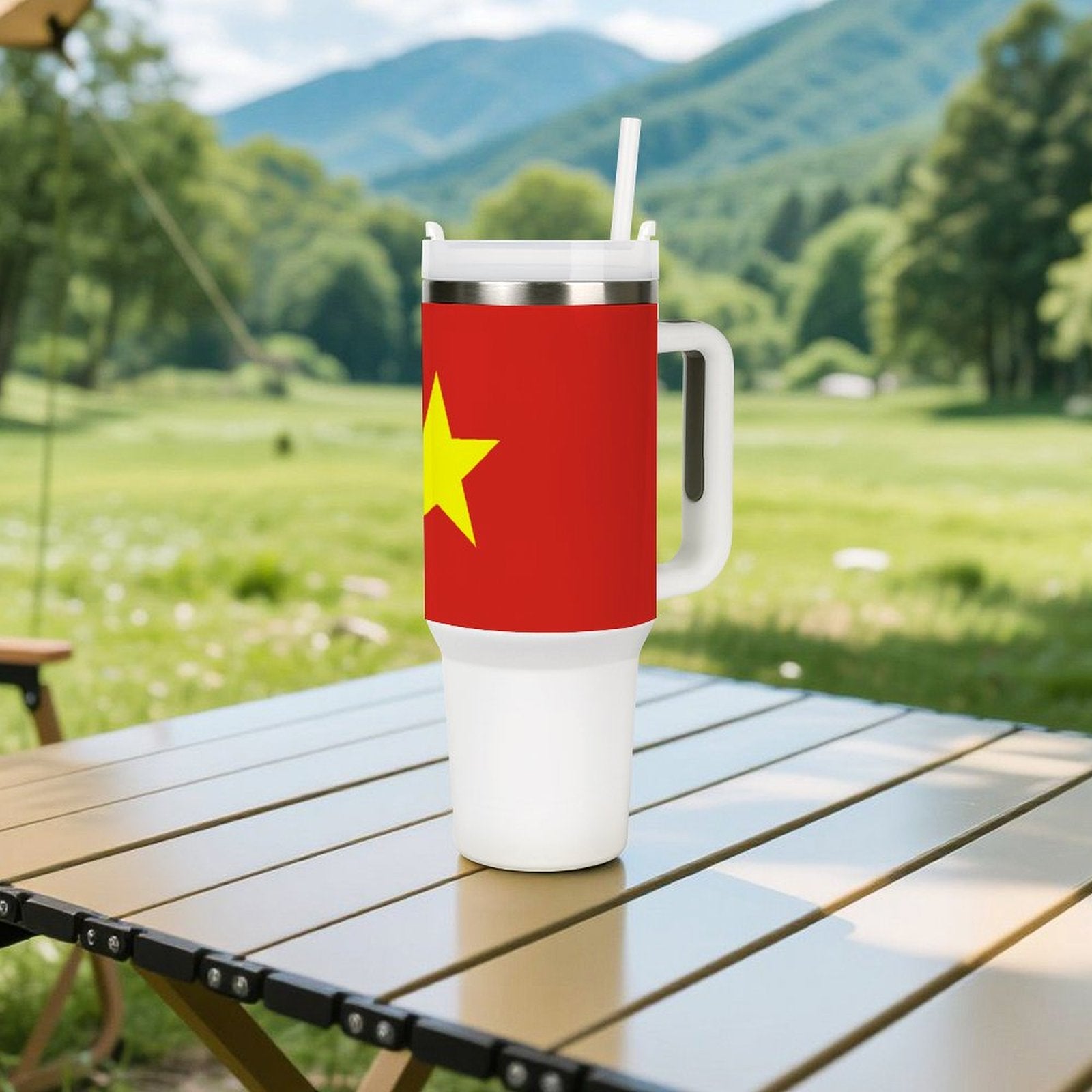 [Brand] tumbler with star design on outdoor table, forested background.