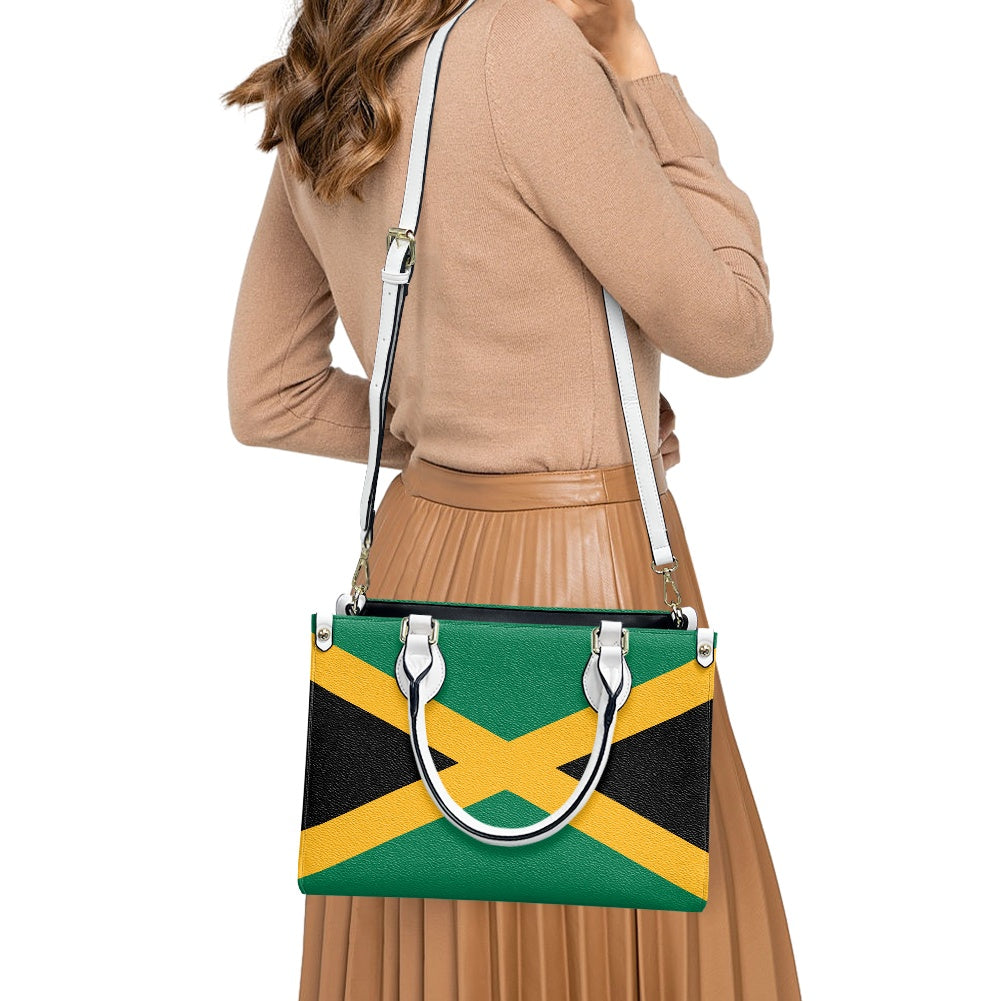 Woman carrying [Brand] Jamaican flag shoulder bag, brown outfit.