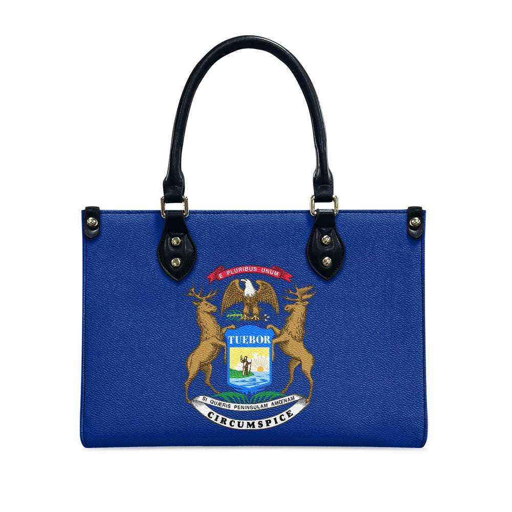 Blue [Brand] handbag featuring Michigan state seal, black handles.