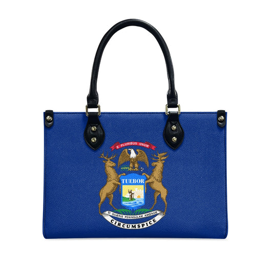 Blue [Brand] handbag featuring Michigan state seal, black handles.
