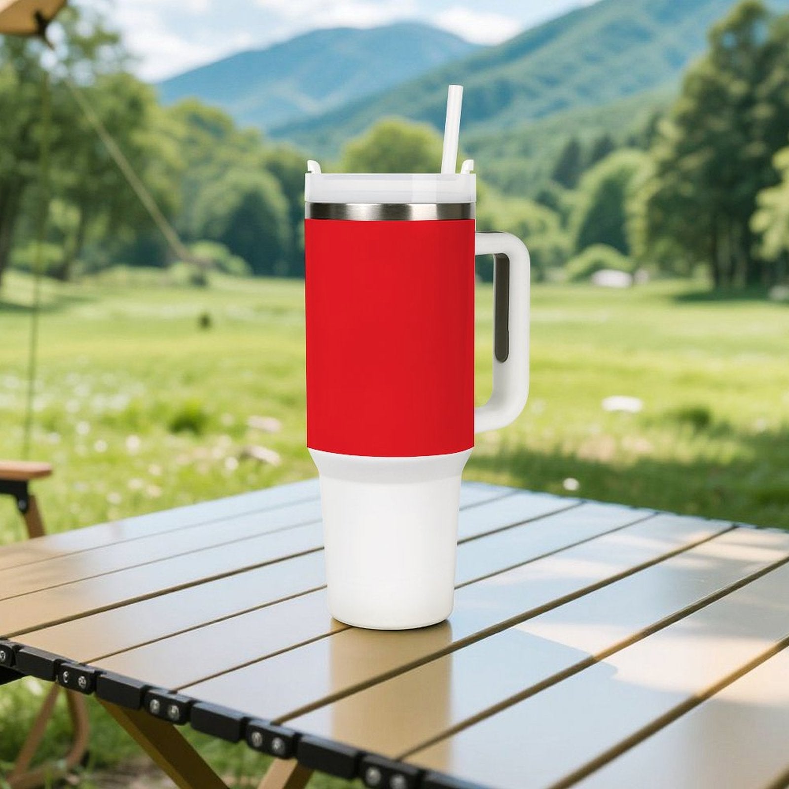 Red [Brand] travel mug with handle on wooden table outdoors.