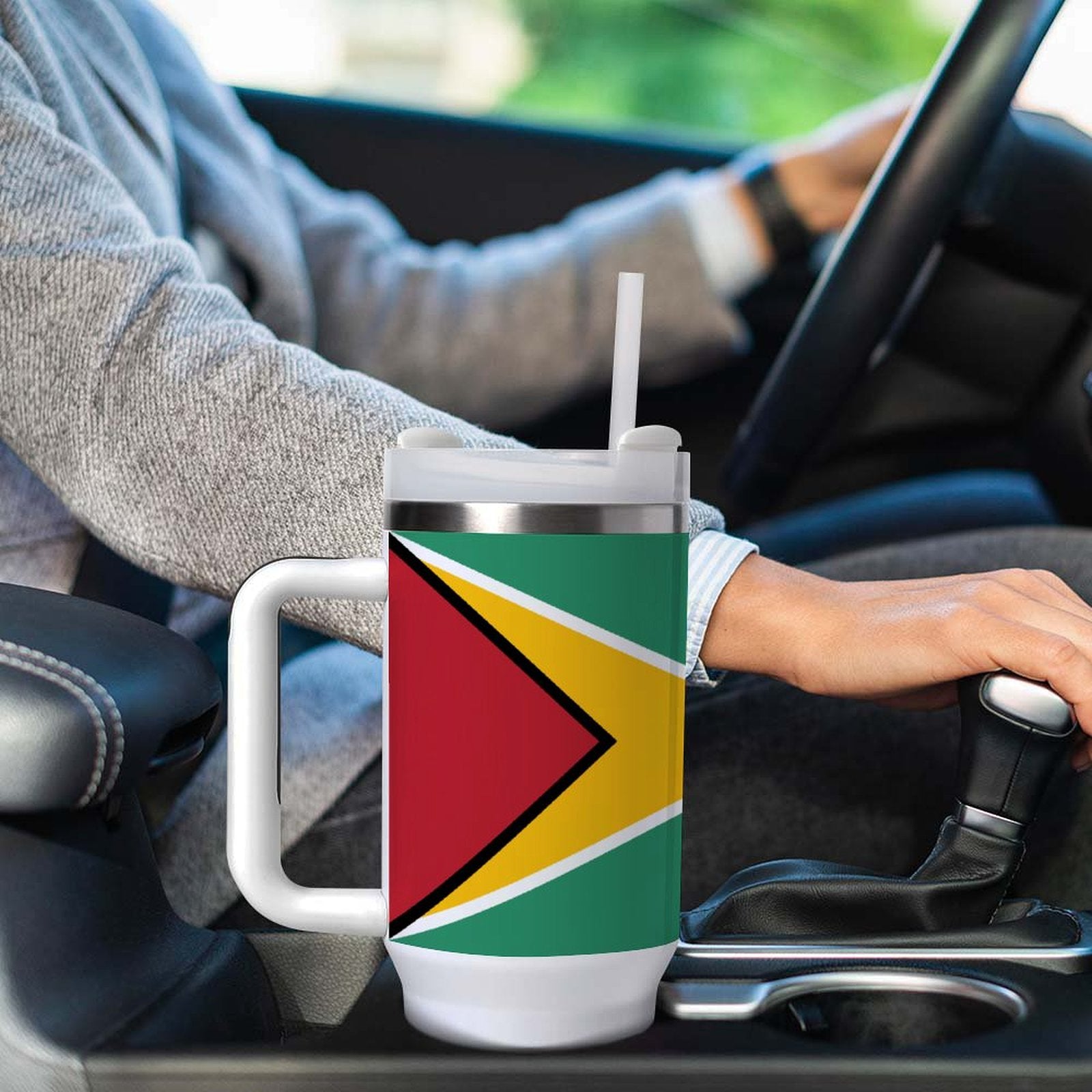 Person driving with [Brand] mug featuring colorful flag design.
