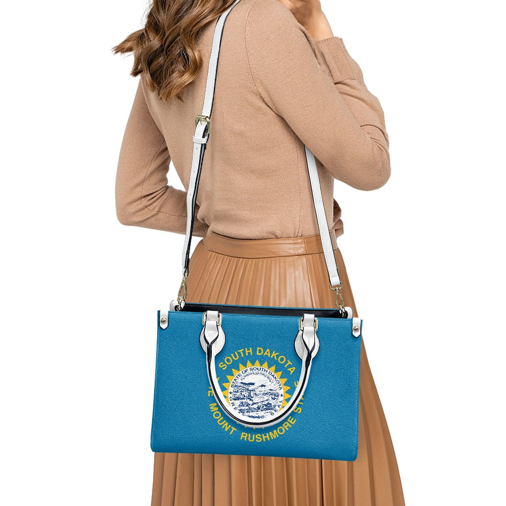 Woman carrying [Brand] blue bag with South Dakota print.