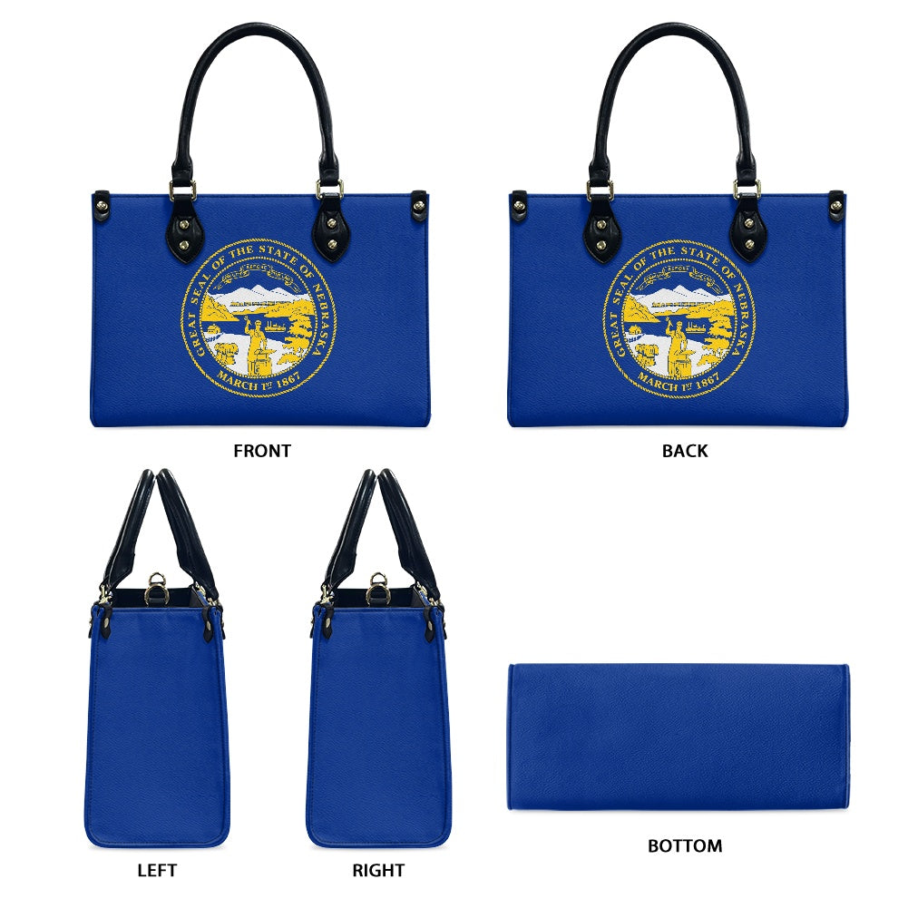 [Brand] blue handbag featuring Nebraska state seal, multiple views.