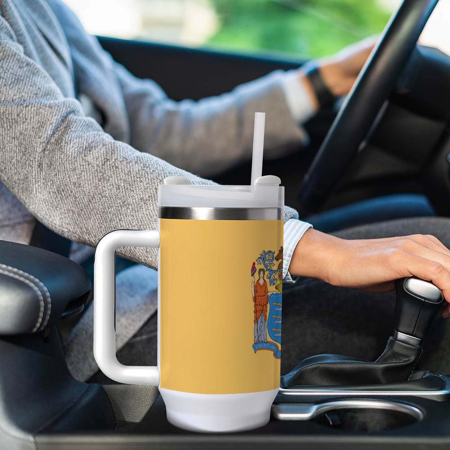 Person driving with a [Brand] mug in cup holder.