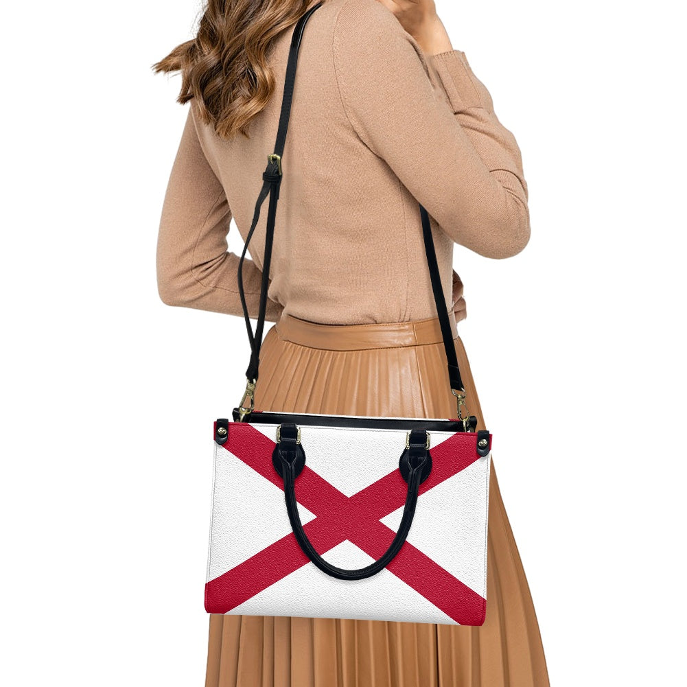 Woman carrying [Brand] handbag with red cross pattern design.