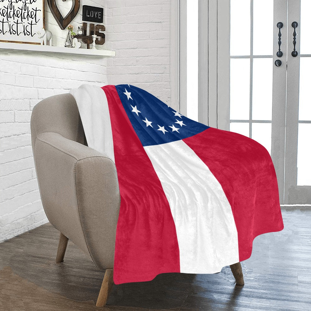 A cozy chair draped with Luv My Flag blanket.