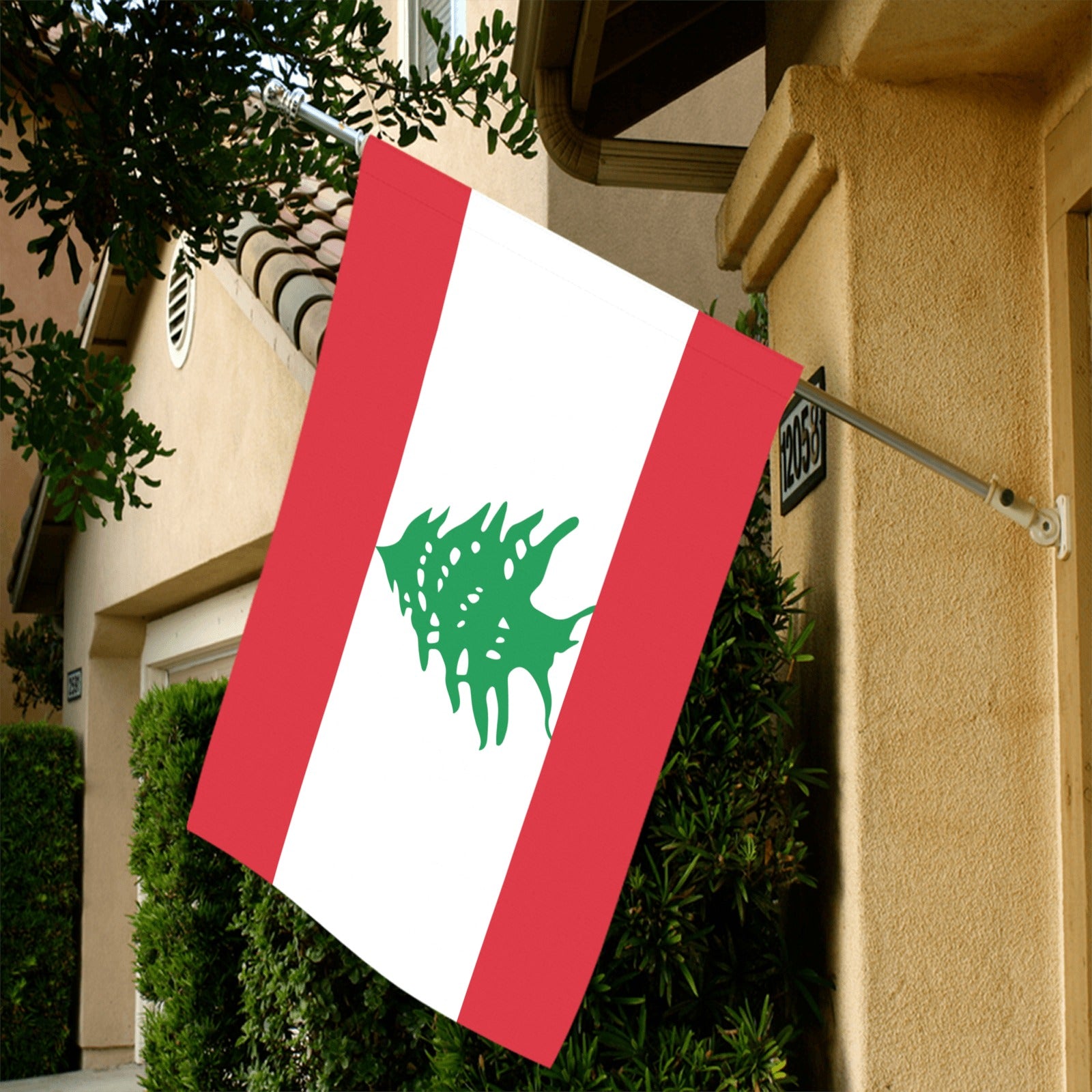 "Luv My Flag Lebanese flag displayed on beige house exterior."