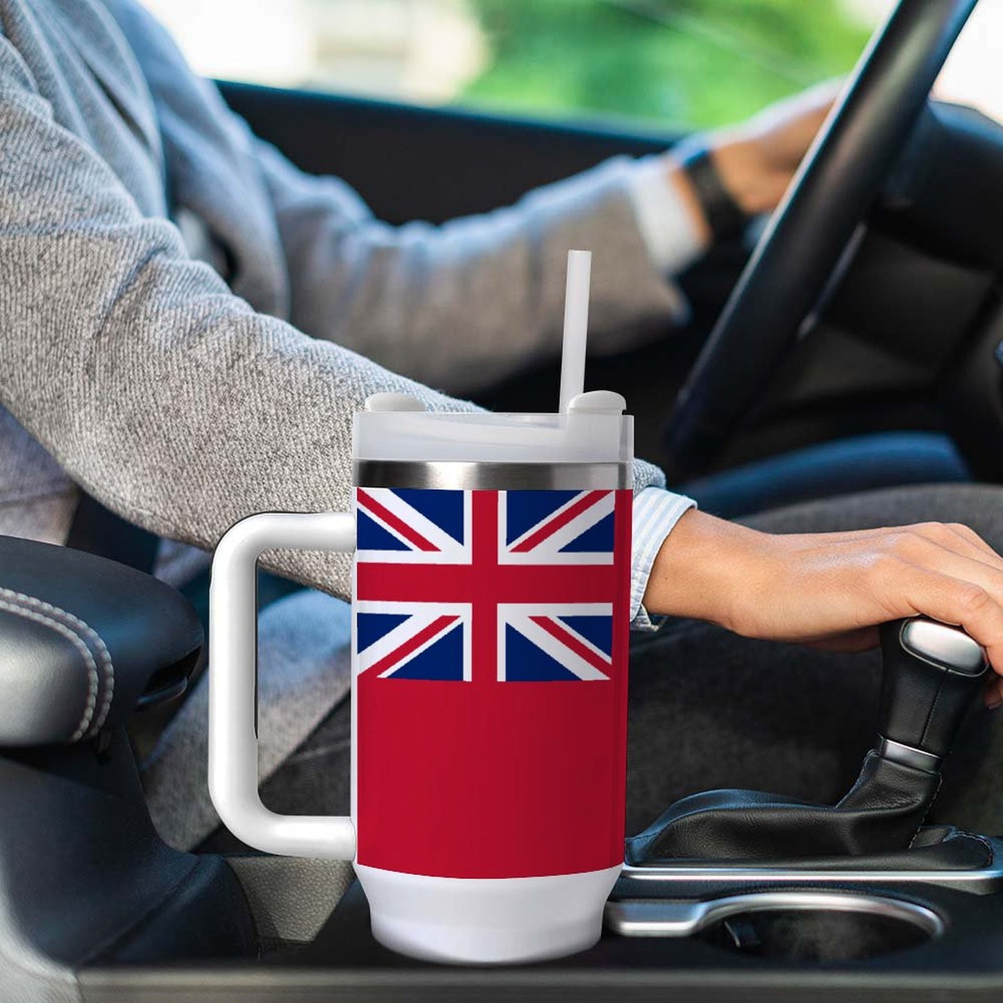 Person driving car with [Brand] mug, British flag design.