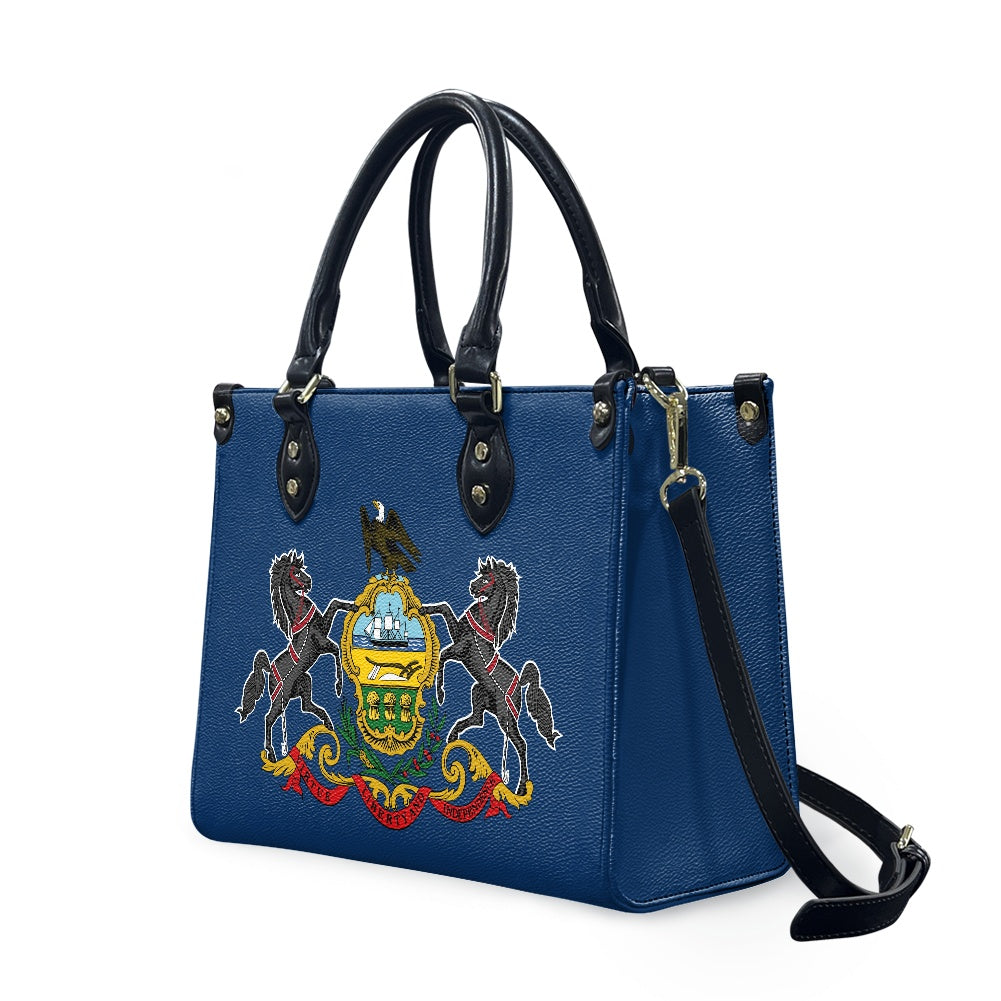 Blue [Brand] handbag with emblem, black handles, and strap.