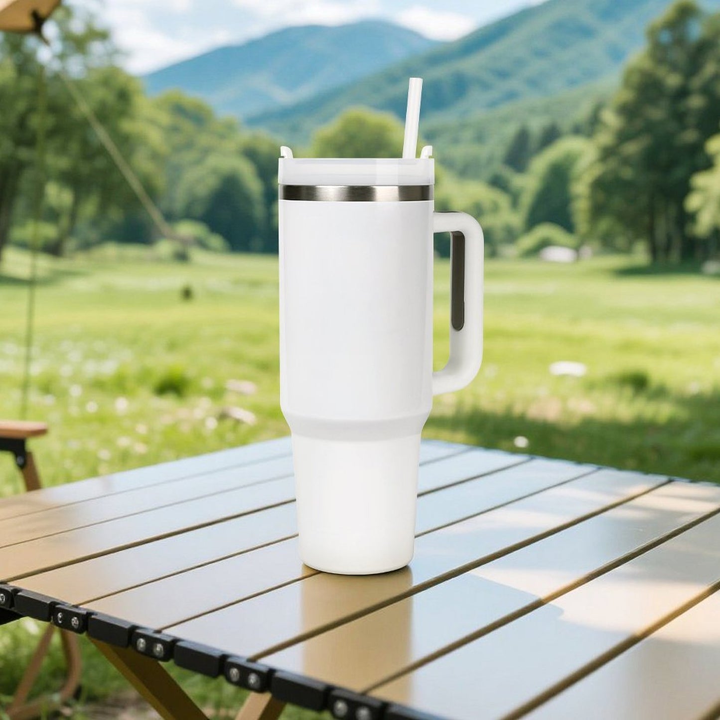 White [Brand] tumbler with straw on outdoor table, mountains.