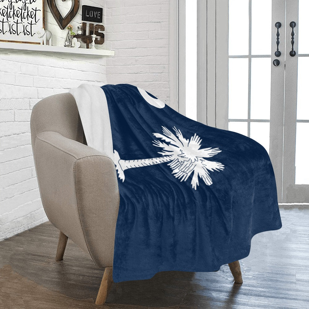Cozy chair with Luv My Flag branded palm tree blanket.