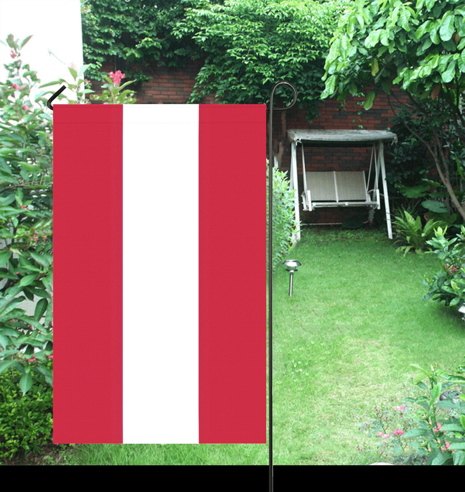Red and white flag in a lush garden setting. [Luv My Flag]
