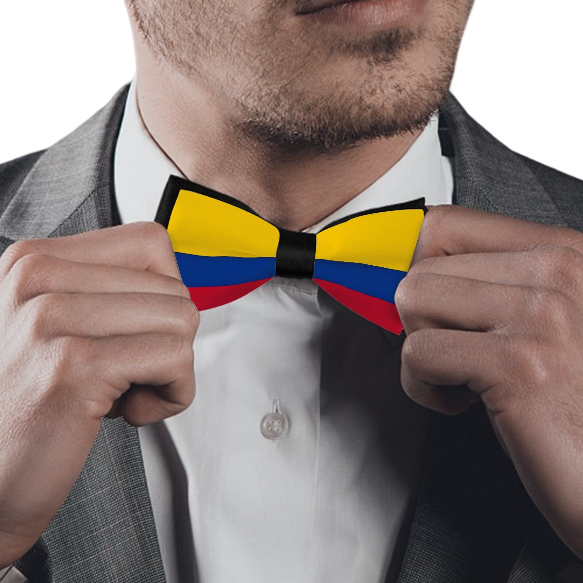 Man adjusting colorful bow tie, [Brand], wearing gray suit.