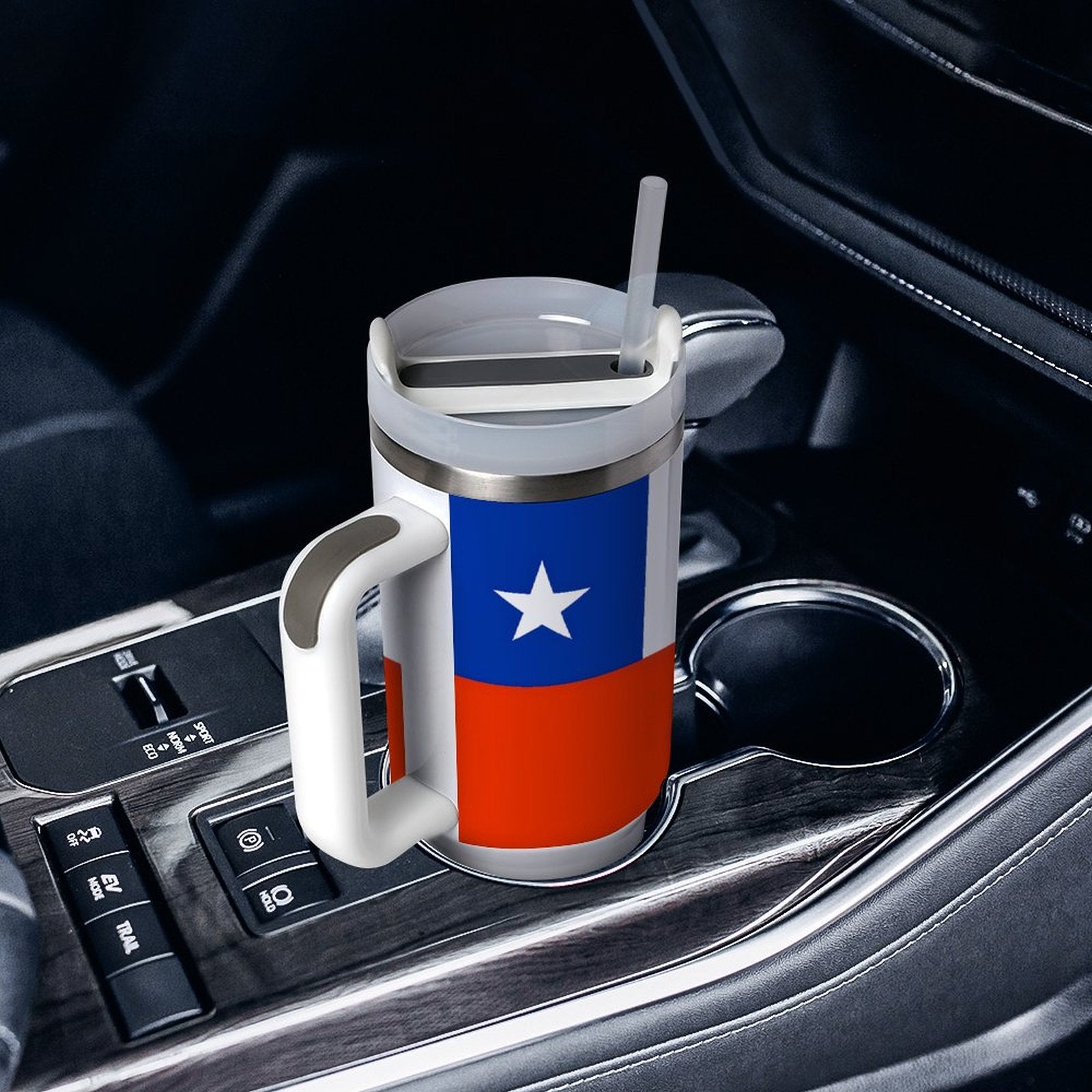 Travel mug with flag design in car cup holder. [Brand]