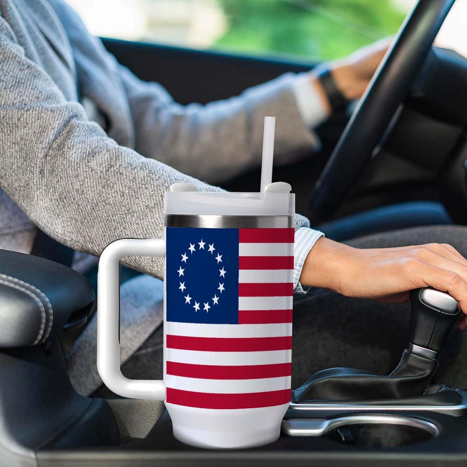 Hand holding gear shift, [Brand] mug with American flag design.