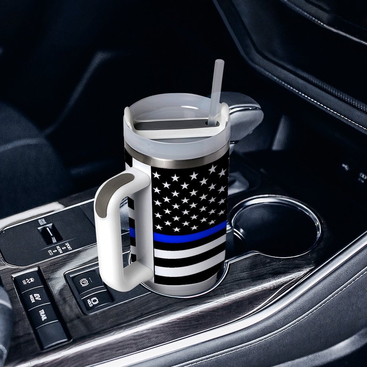 [Brand] travel mug with flag design in car cupholder.
