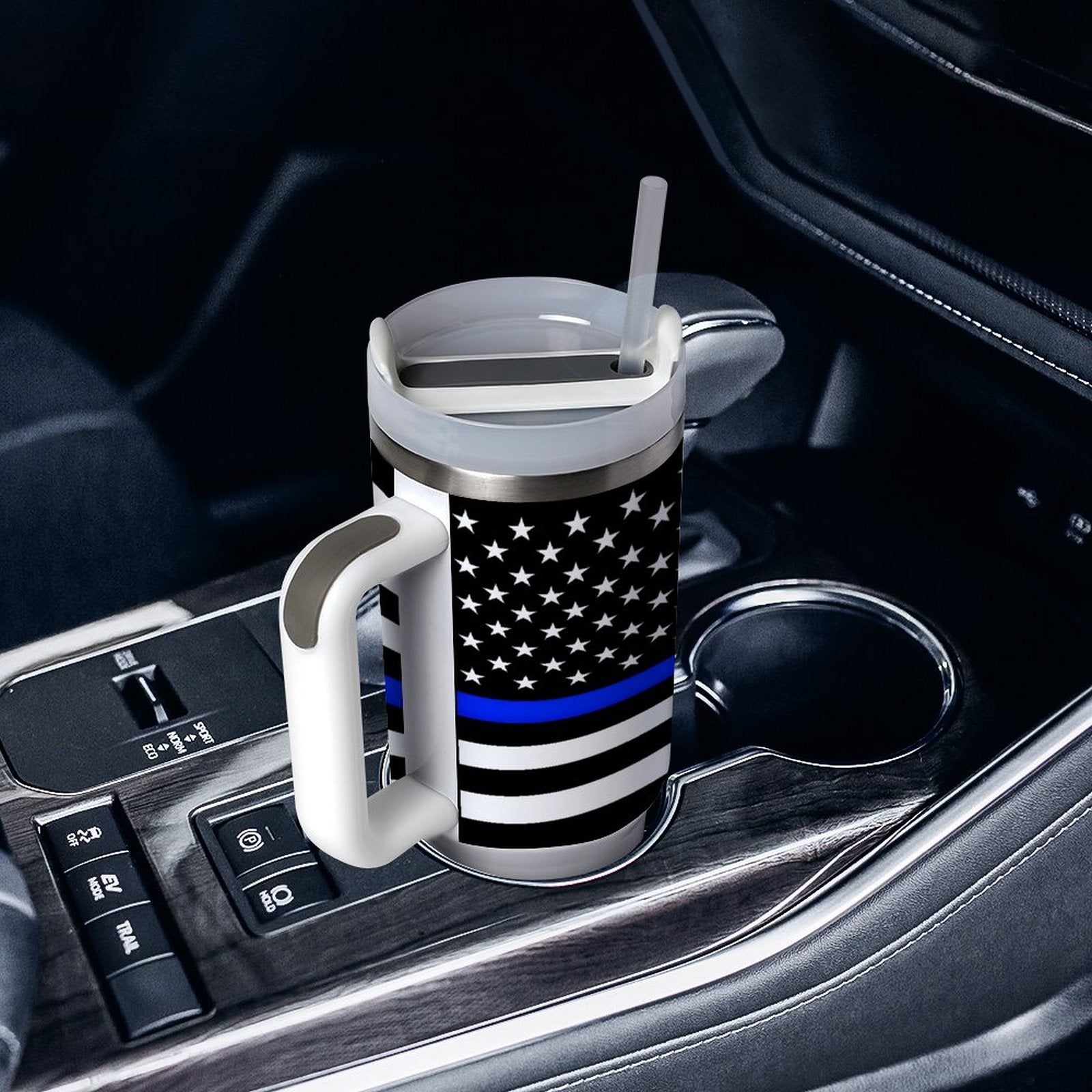 [Brand] travel mug with flag design in car cupholder.