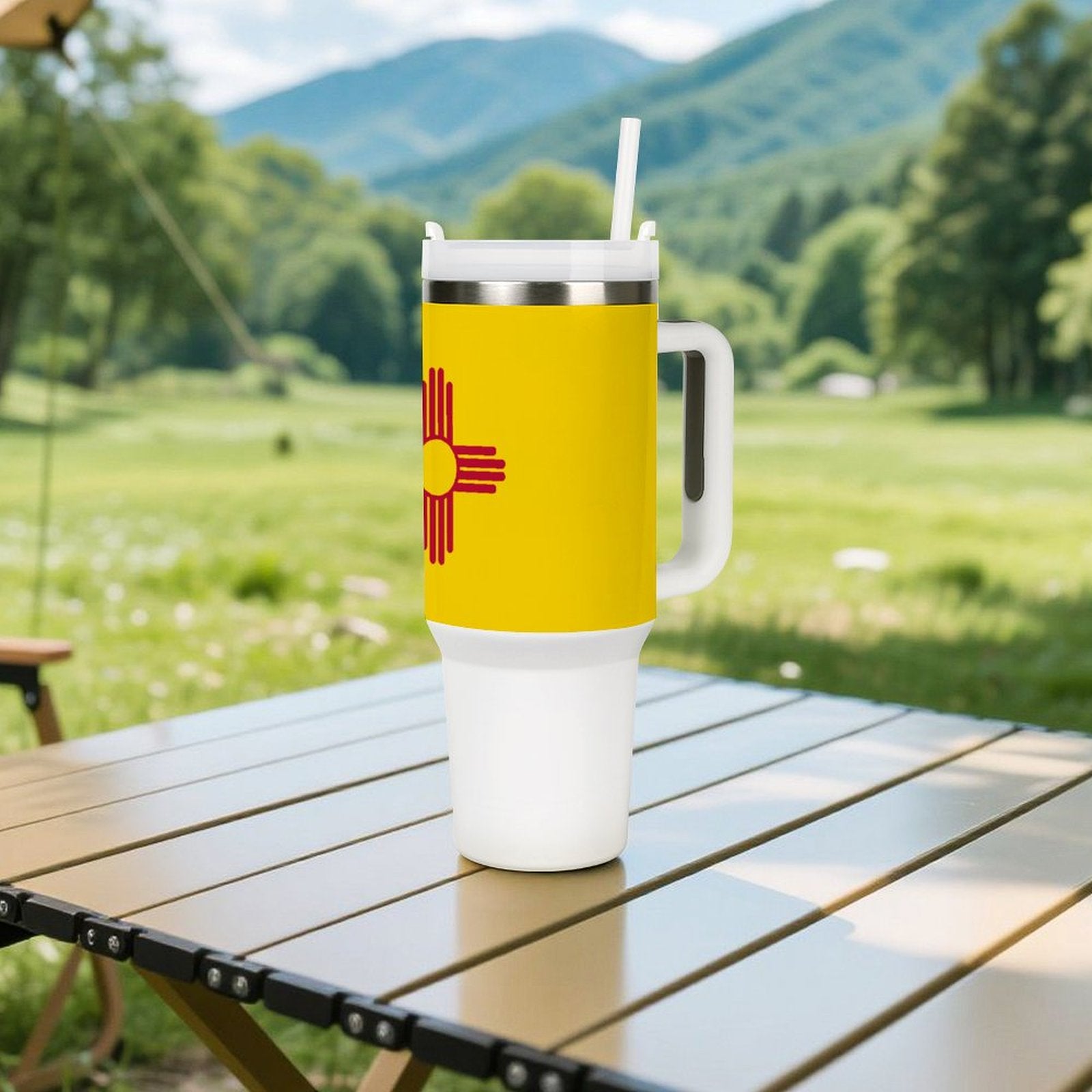Yellow [Brand] tumbler with handle on table, scenic background.