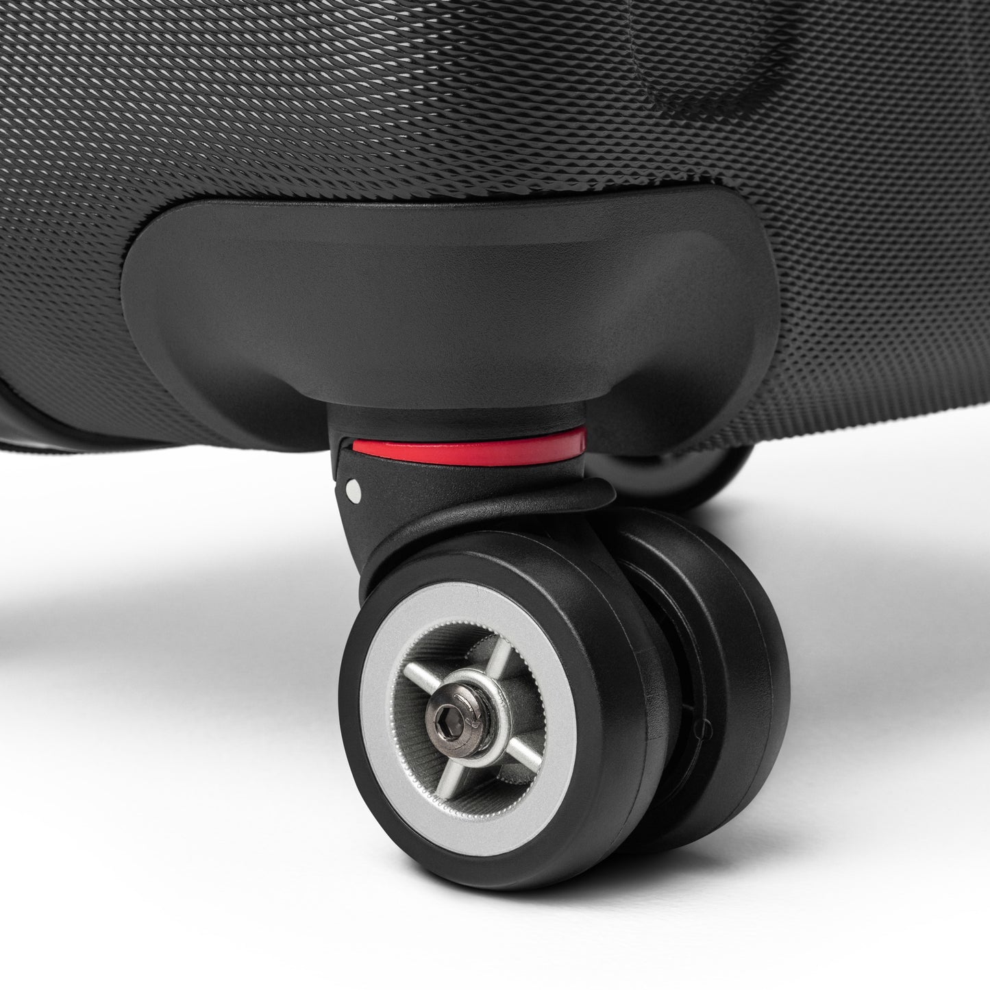 Close-up of [Brand] suitcase wheel with textured black surface.