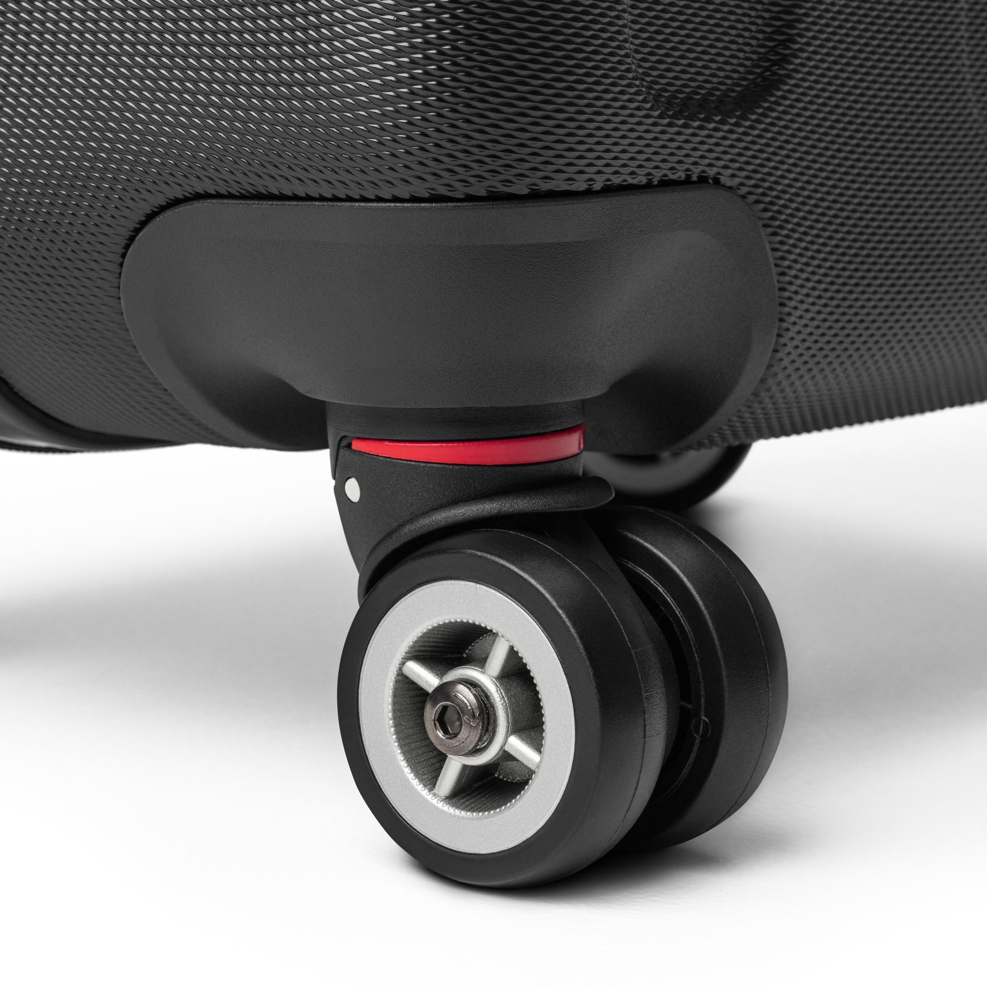 Close-up of [Brand] suitcase wheel with textured black surface.